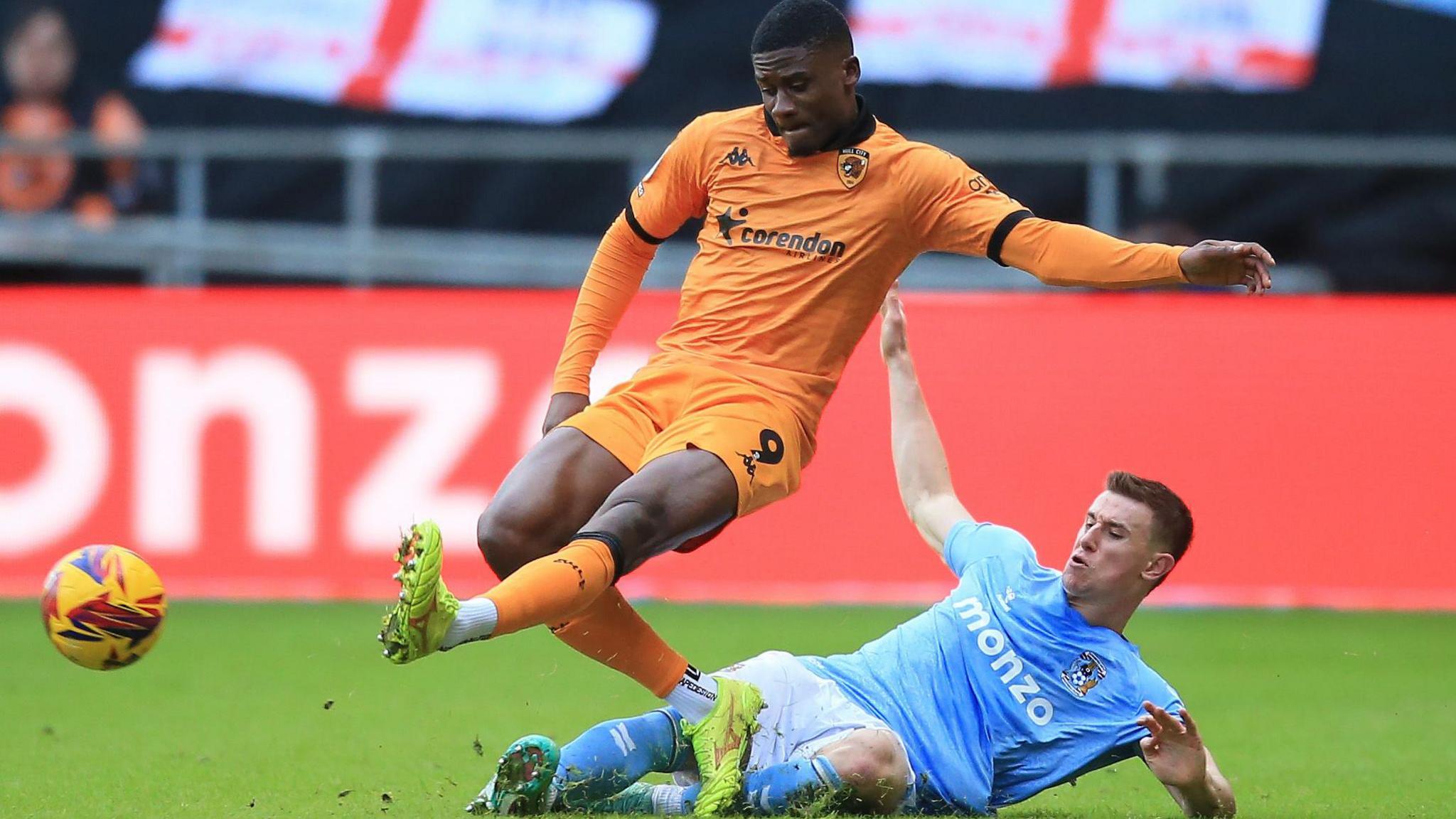 Coventry midfielder Bean Sheaf slides to tackle Hull's Chris Bedia 