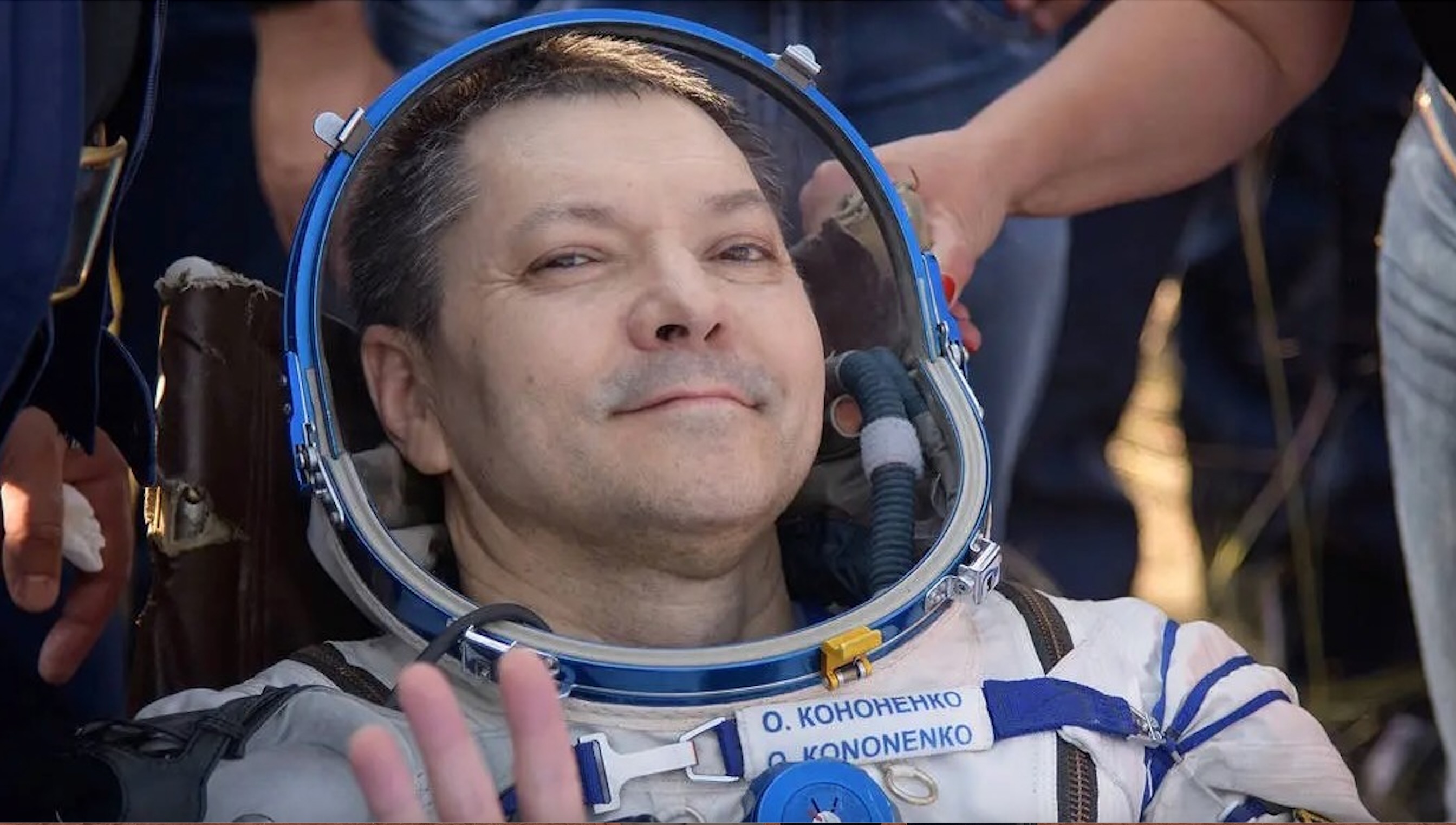 closeup of a smiling man in a white spacesuit