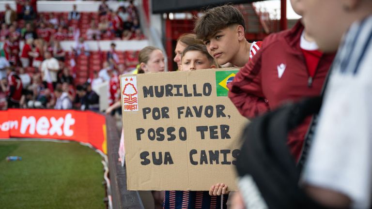 A spectator holds a home-made sign appealing for the gift of Murillo's shirt