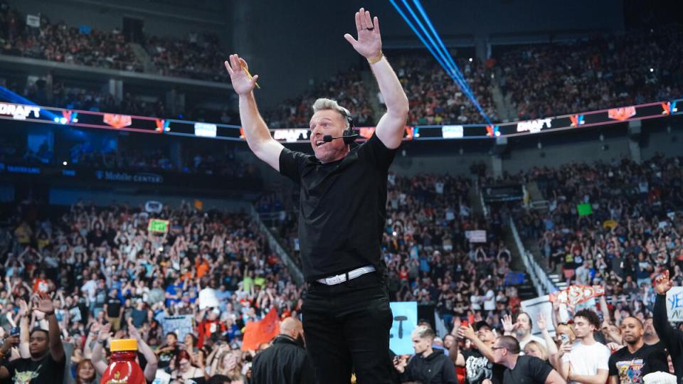 A man with arms raised in a large crowd.