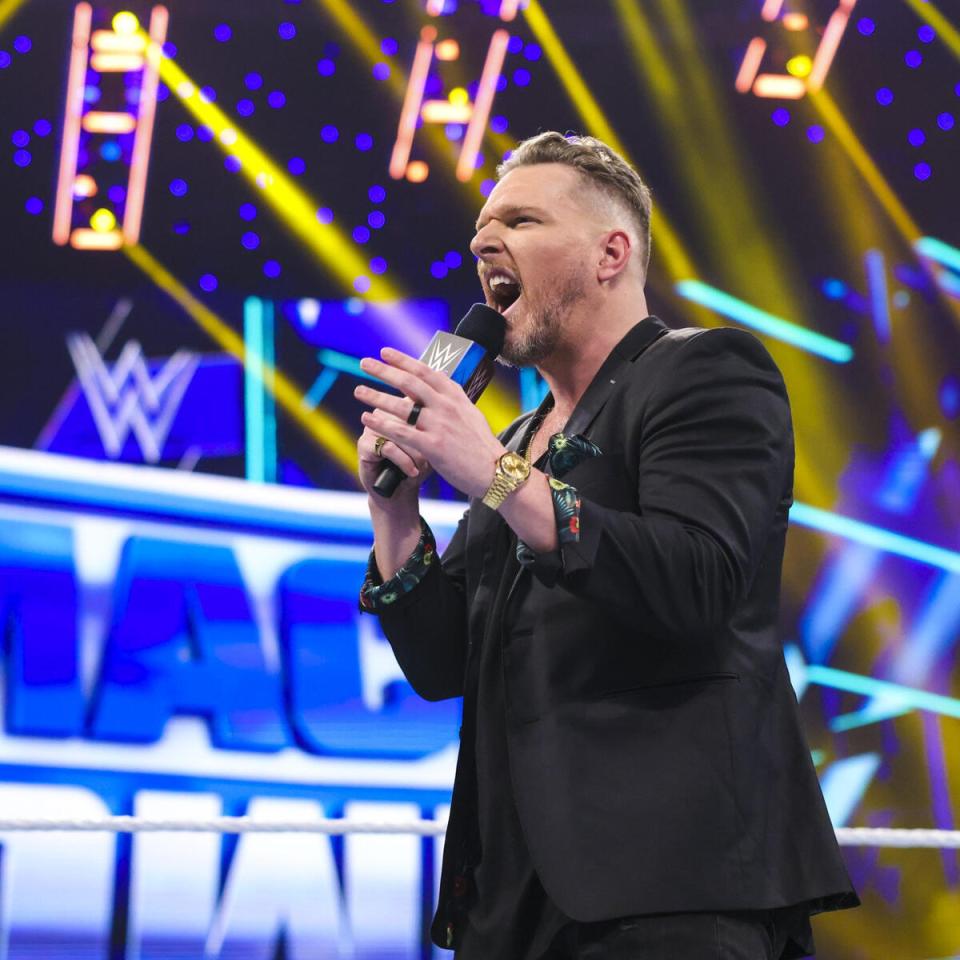 Pat McAfee speaking into a microphone at a WWE event.