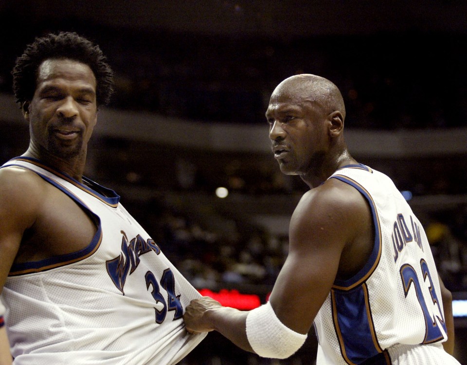 Michael Jordan holding back Charles Oakley during a basketball game.