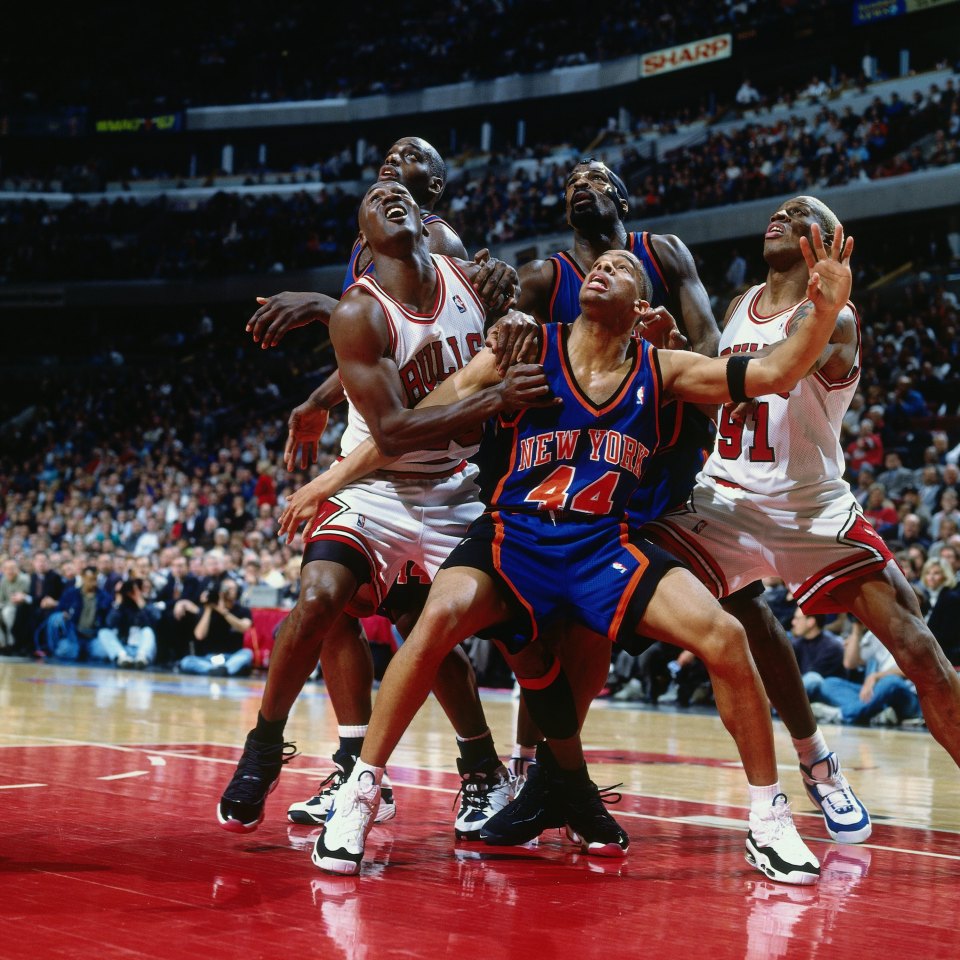 New York Knicks and Chicago Bulls players vying for the ball during an NBA game.