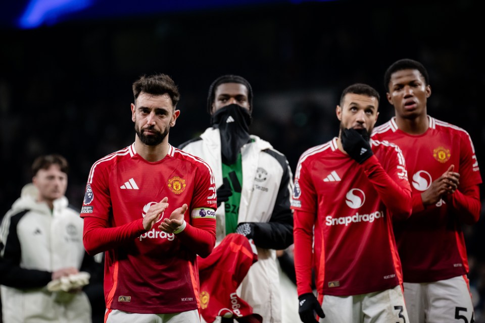 Manchester United players applaud fans after a Premier League match.