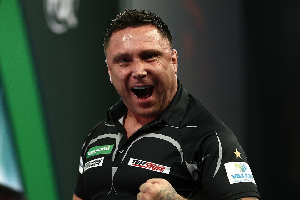 Gerwyn Price celebrating during a darts match.