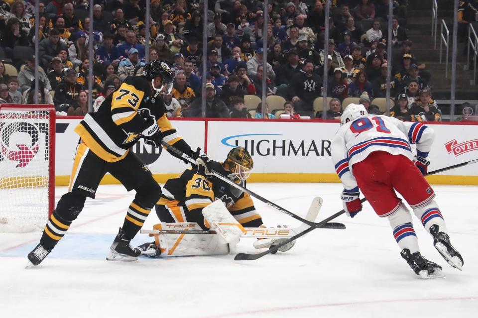 Feb 23, 2025; Pittsburgh, Pennsylvania, USA; Pittsburgh Penguins goaltender Joel Blomqvist (30) makes a save against New York Rangers right wing Reilly Smith (91) as Penguins defenseman P.O Joseph (73) assists in defending during the third period at PPG Paints Arena. (Charles LeClaire-Imagn Images)