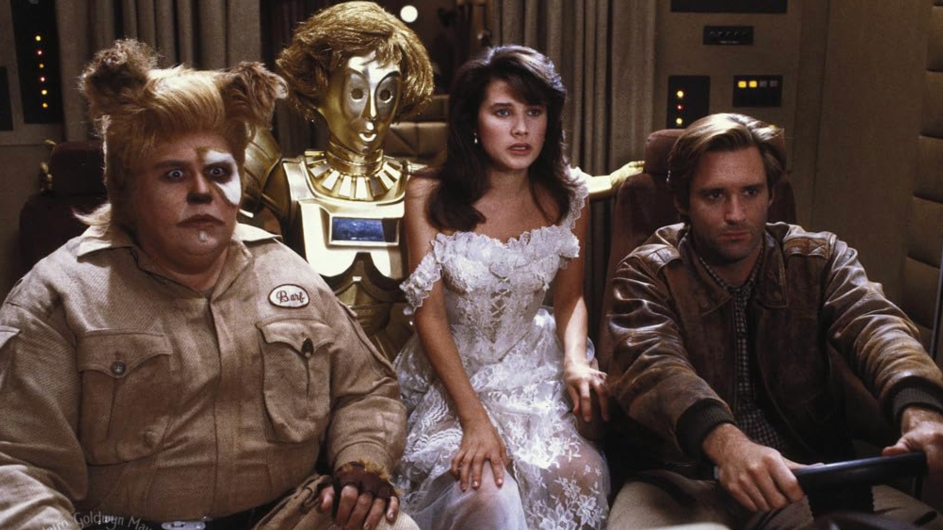 Scene from the Star Wars spoof film Spaceballs (1987). From left to right we have a space dog-humanoid called Barf (Chewbacca parody), a female C-3P0, a Princess Leia parody, and a Han Solo parody.