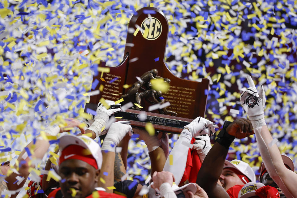 ATLANTA, GEORGIA - DECEMBER 7: The Georgia Bulldogs celebrate and hold the SEC Championship trophy following the 22-19 victory over the Texas Longhorns in the 2024 SEC Championship at Mercedes-Benz Stadium on December 7, 2024 in Atlanta, Georgia. (Photo by Todd Kirkland/Getty Images)