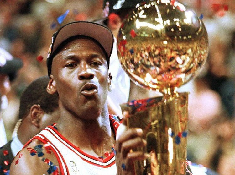 Michael Jordan holding the Larry O'Brien trophy.