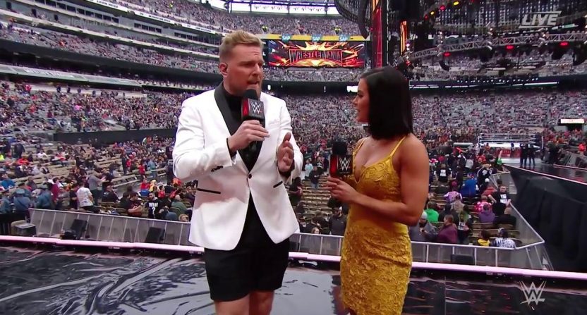 Two WWE hosts interviewing in front of a large crowd.