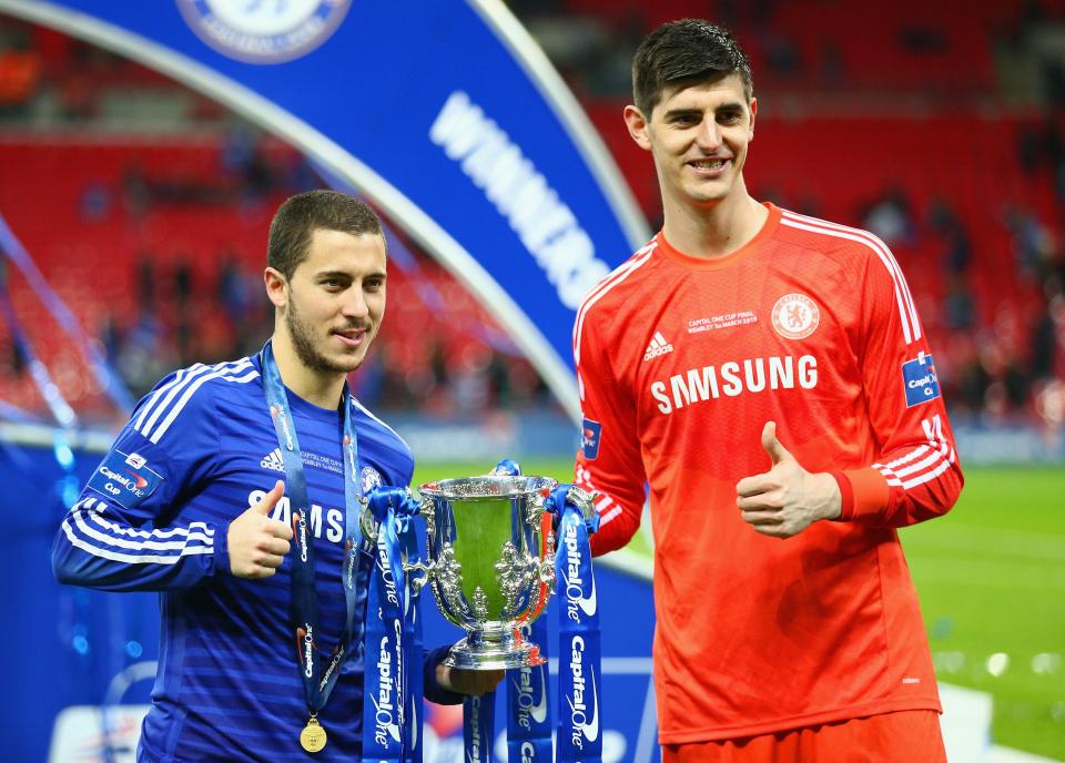 Eden Hazard and Thibaut Courtois with a trophy and medals.