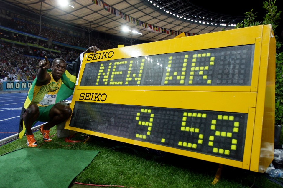 Usain Bolt next to a scoreboard displaying his world record 100m sprint time of 9.58 seconds.