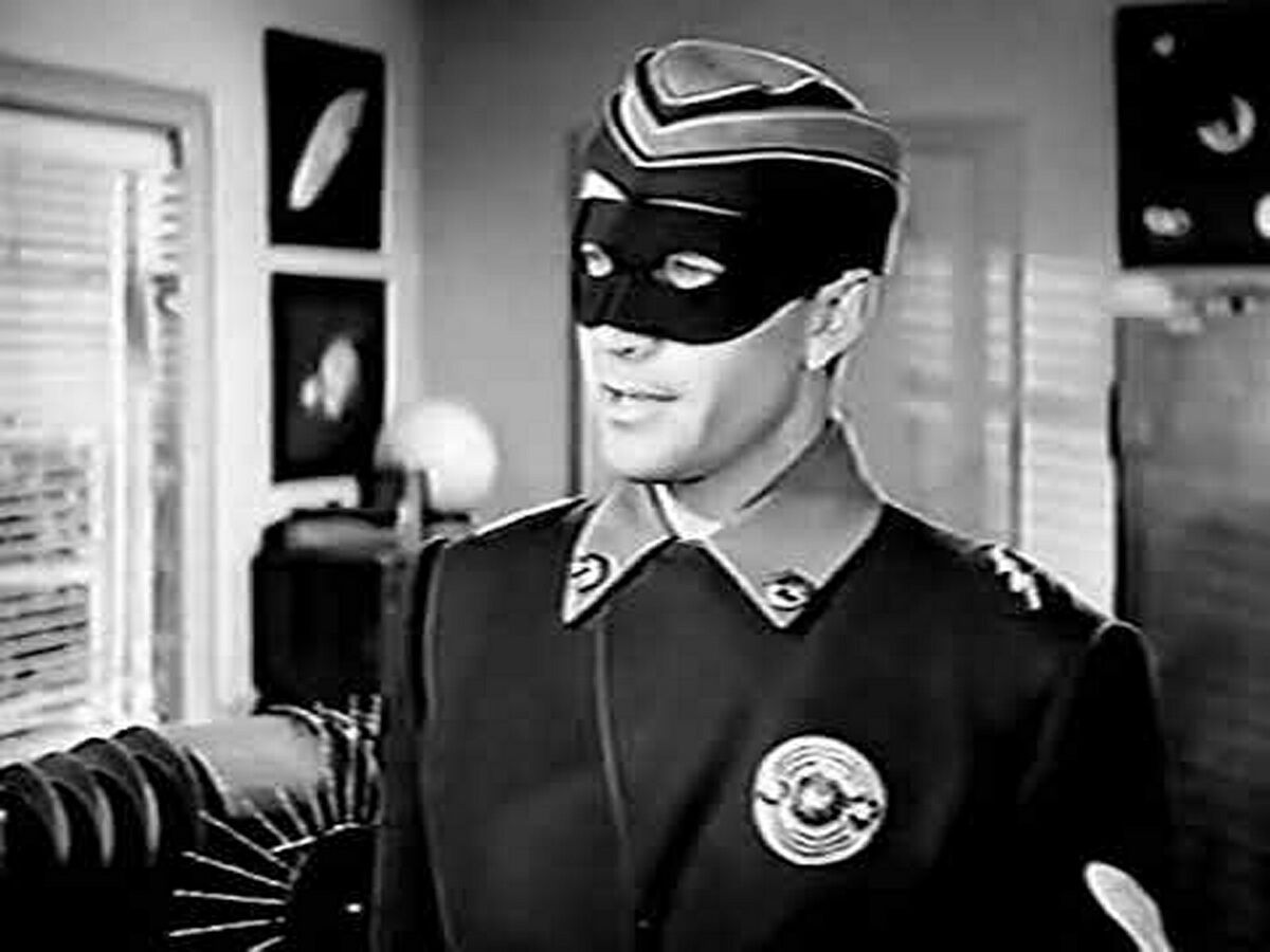 A man in a futuristic uniform and black mask over his eyes