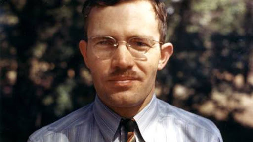 A man with brown hair and glasses.