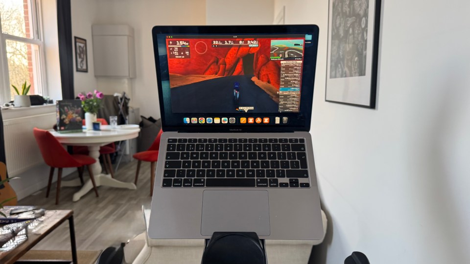 Laptop displaying Zwift cycling game.