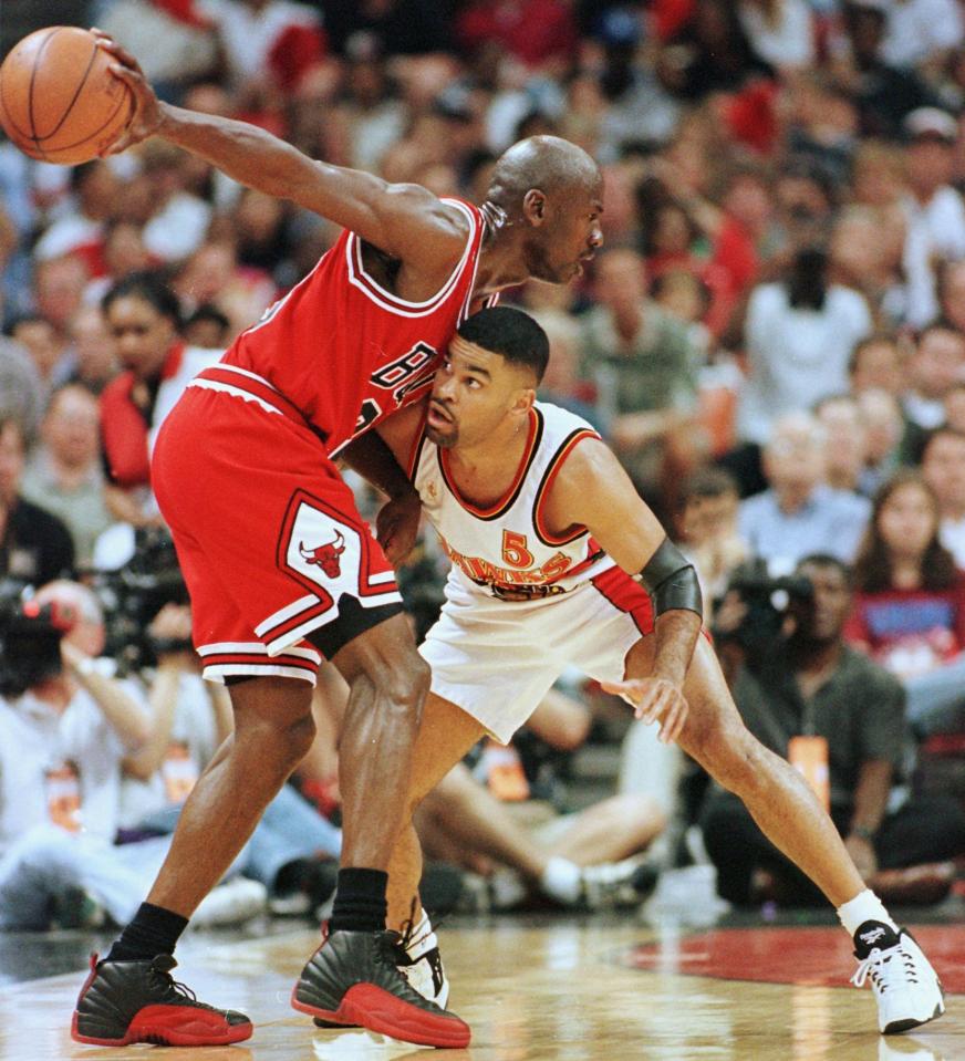 Michael Jordan guarding Eldridge Recasner during a basketball game.