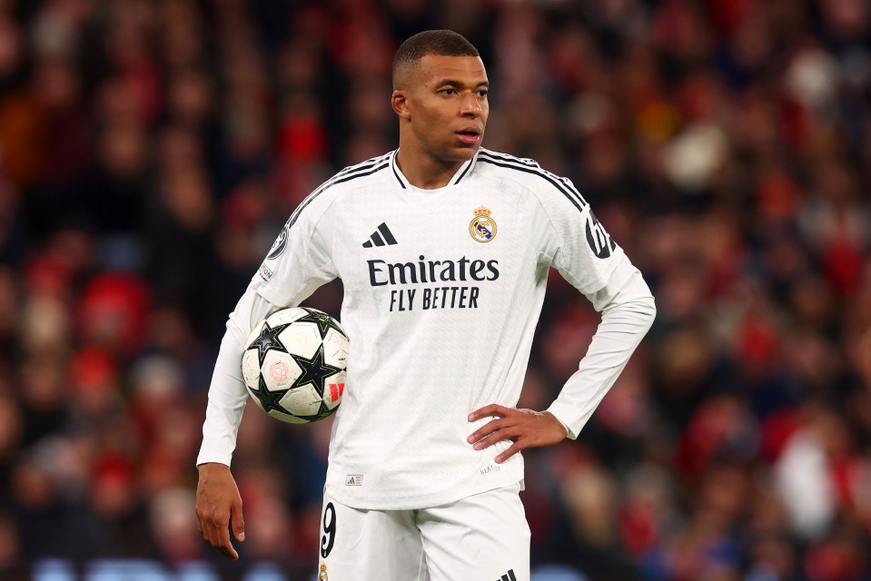 Kylian Mbappé of Real Madrid holding a soccer ball.