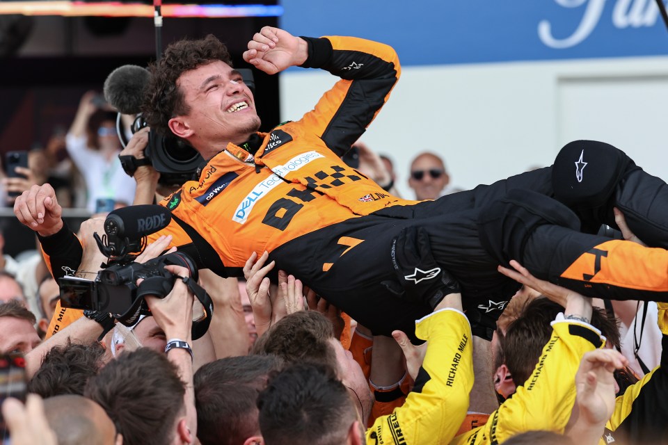 Lando Norris of McLaren F1 Team being celebrated by a crowd after winning a race.