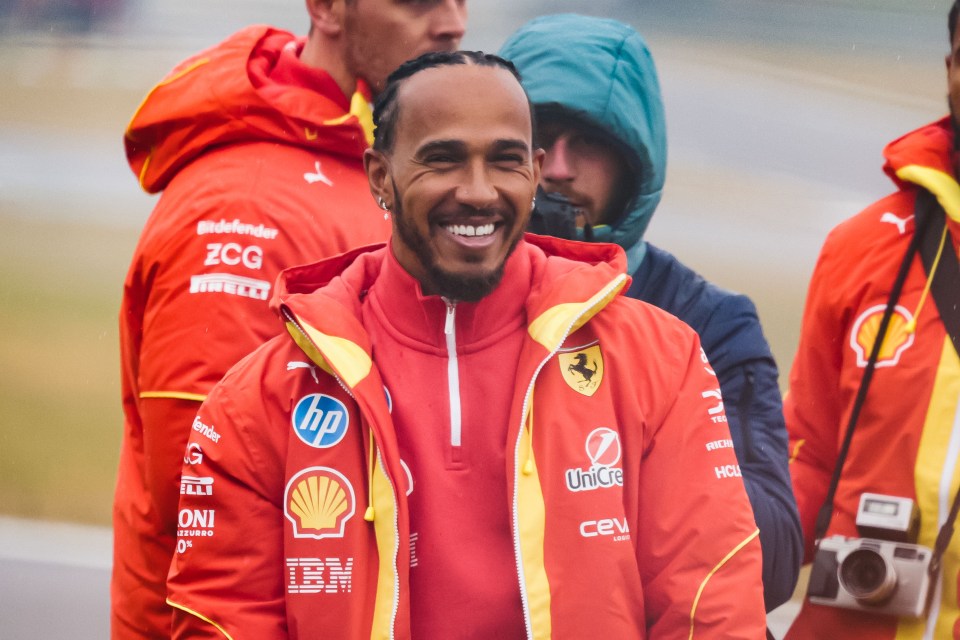 Lewis Hamilton smiling in a Ferrari jacket at a test drive.