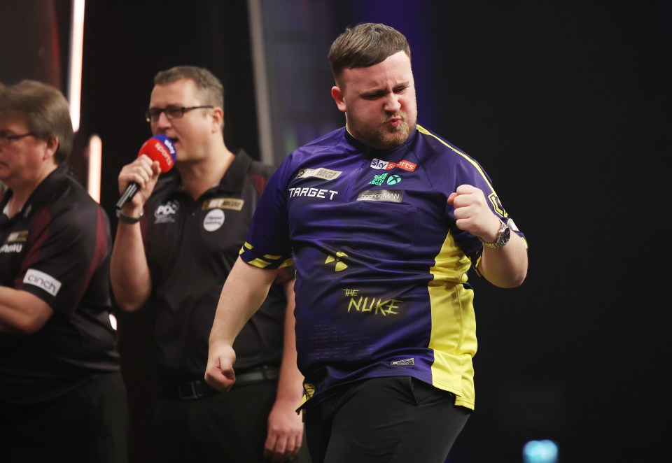 Luke Littler celebrates a win at a darts competition.