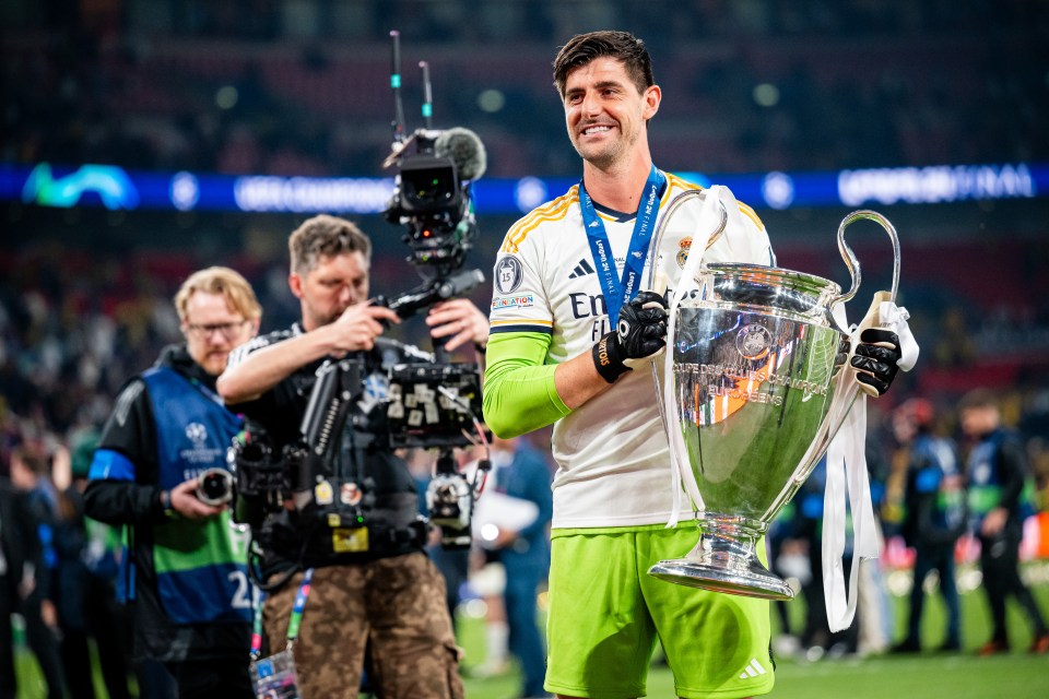 Thibaut Courtois of Real Madrid holding the UEFA Champions League trophy.