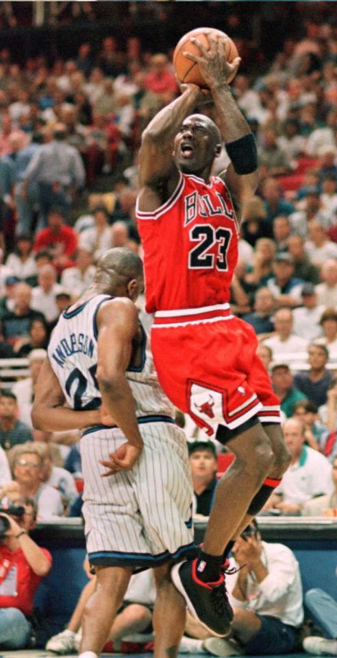 Michael Jordan making a jump shot in a basketball game.