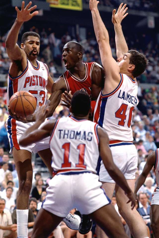 Michael Jordan driving to the basket, defended by Detroit Pistons players.