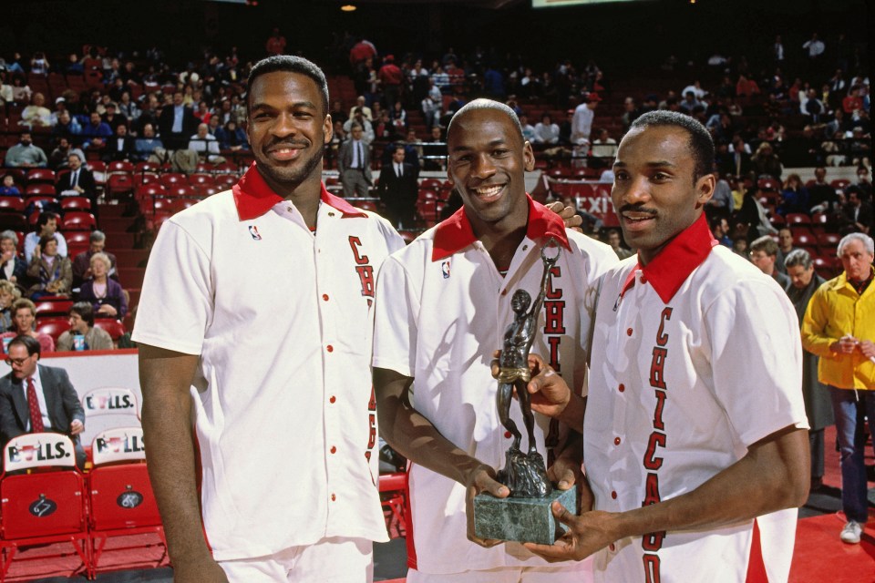 Chicago Bulls players Charles Oakley, Michael Jordan, and Rory Sparrow holding an award.