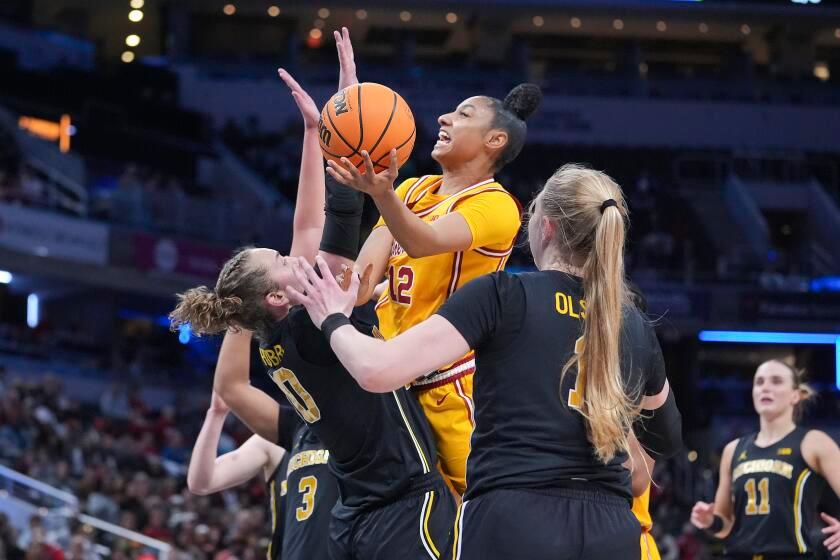 Southern California guard JuJu Watkins (12) shoots on Michigan guard Jordan Hobbs (10) during the first half of an NCAA college basketball game in the semifinals of the Big Ten Conference tournament in Indianapolis, Saturday, March 8, 2025. (AP Photo/Michael Conroy)