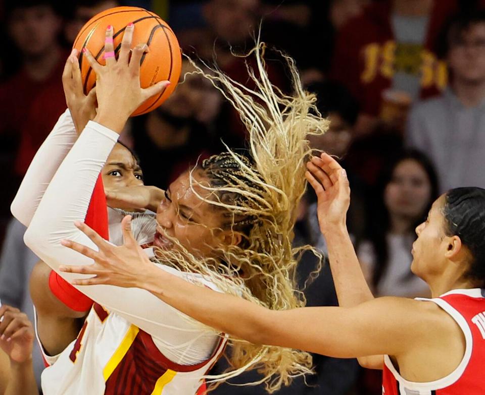 USC forward Kiki Iriafen, center, grabs a rebound over Ohio State forward Ajae Petty.