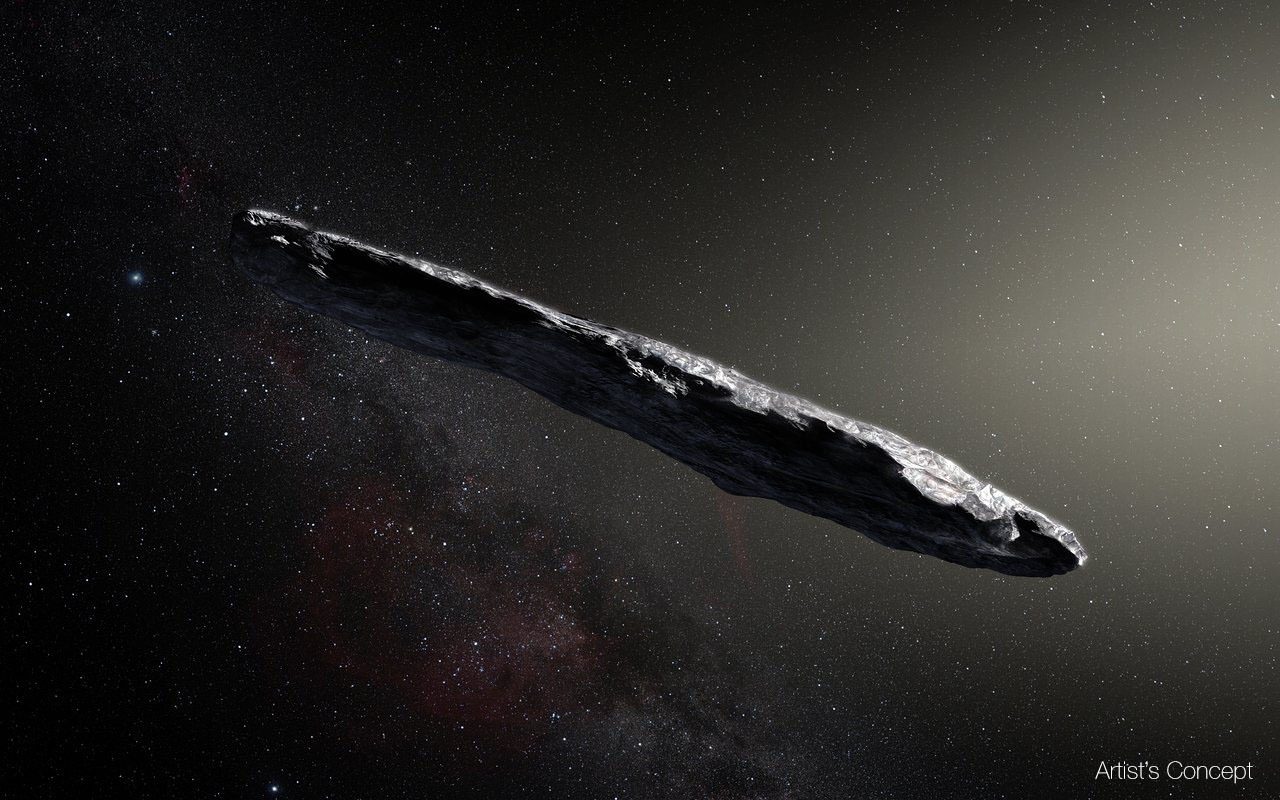 A cigar-shaped grey asteroid against a smoky black cosmic background