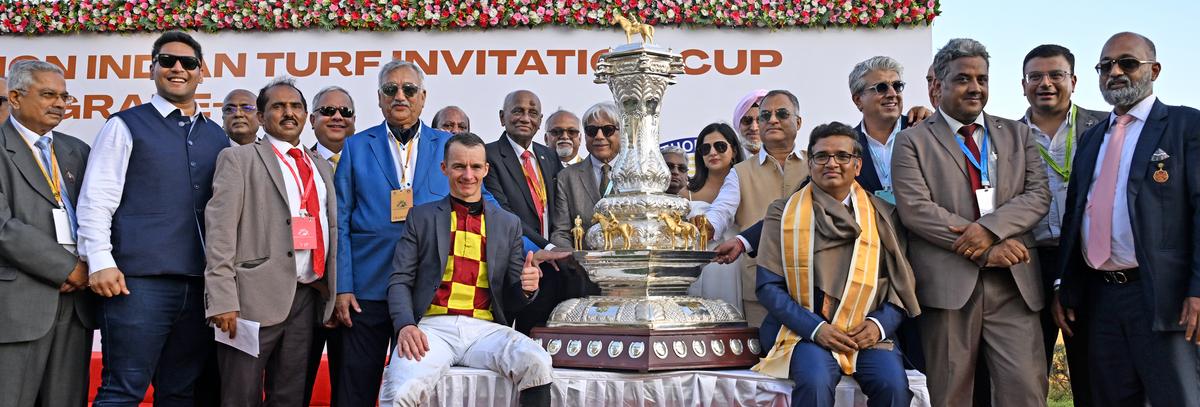 The chairman of the Madras Race Club Muthiah Ramaswamy (right), along with Redefined’s trainer Prasanna Kumar (third from right), HPSL chairman Suresh Paladugu (seated right of the trophy), jockey David Allan, co-owners Ram Shroff (second from right), Ashok Ranpise (behind Paladugu) and Surendra Ramchandra Sanas (blue jacket), HRC chairman R. Surender Reddy (behind Allan), and other dignitaries pose with majestic Invitation Cup.