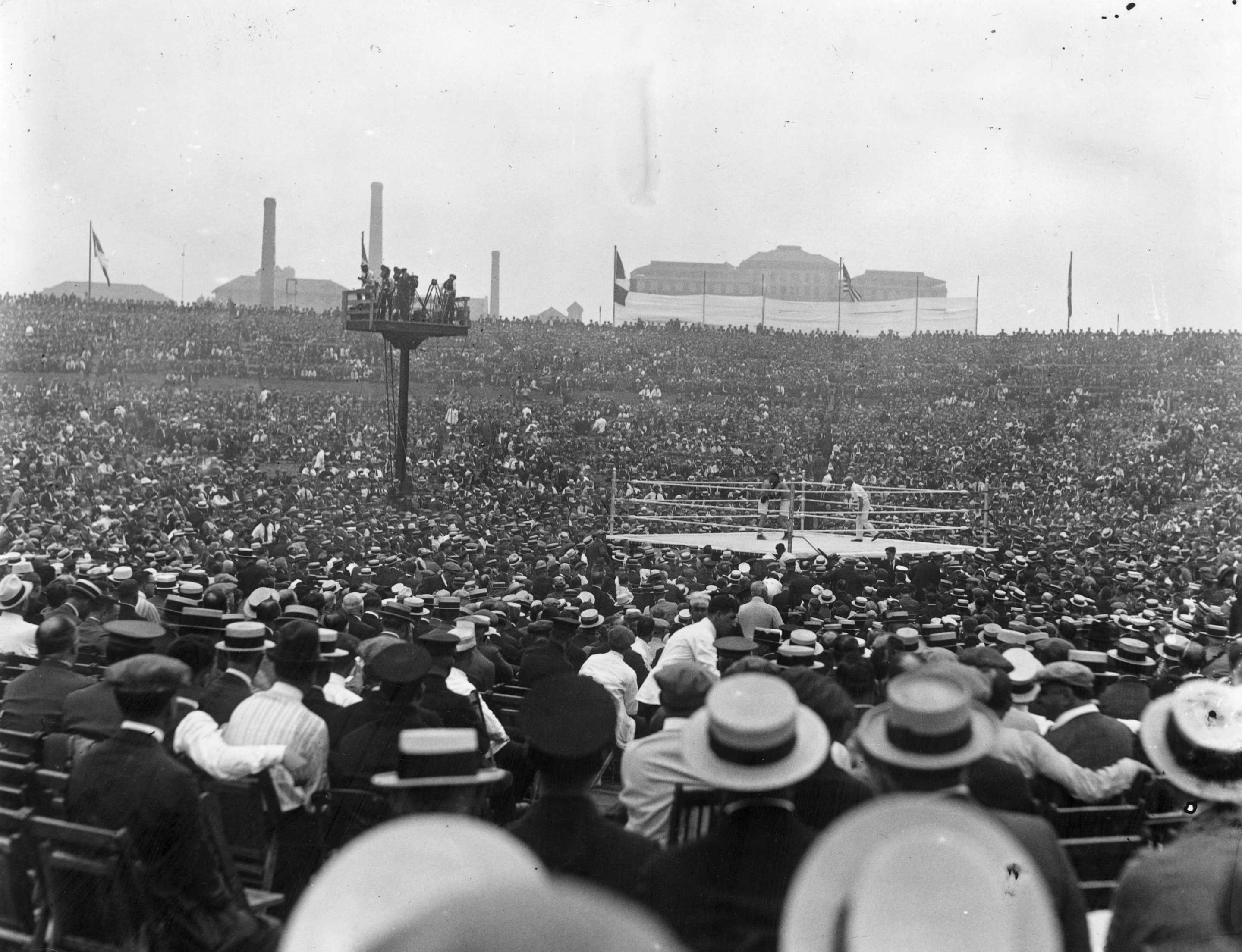 2nd July 1921:  A general view of the crowd watching the world heavyweight title fight between the Ongoing champion Jack Dempsey of the USA and French contender Georges Carpentier at Boyle's Thirty Acres in Jersey City, New Jersey. Dempsey retained his title with a Number four Stage knockout. The fight drew the Primary-ever million-dollar gate.  (Photo by Topical Press Agency/Getty Images)