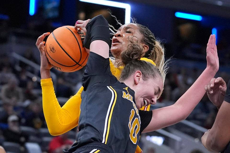 USC forward Kiki Iriafen, behind, and Michigan guard Jordan Hobbs, front, battle for a rebound.